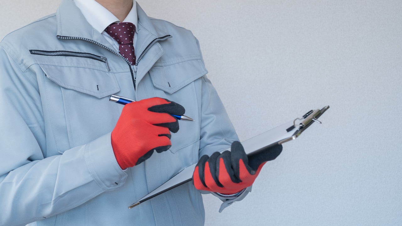 解体業者がバインダーを持ってメモを取る様子