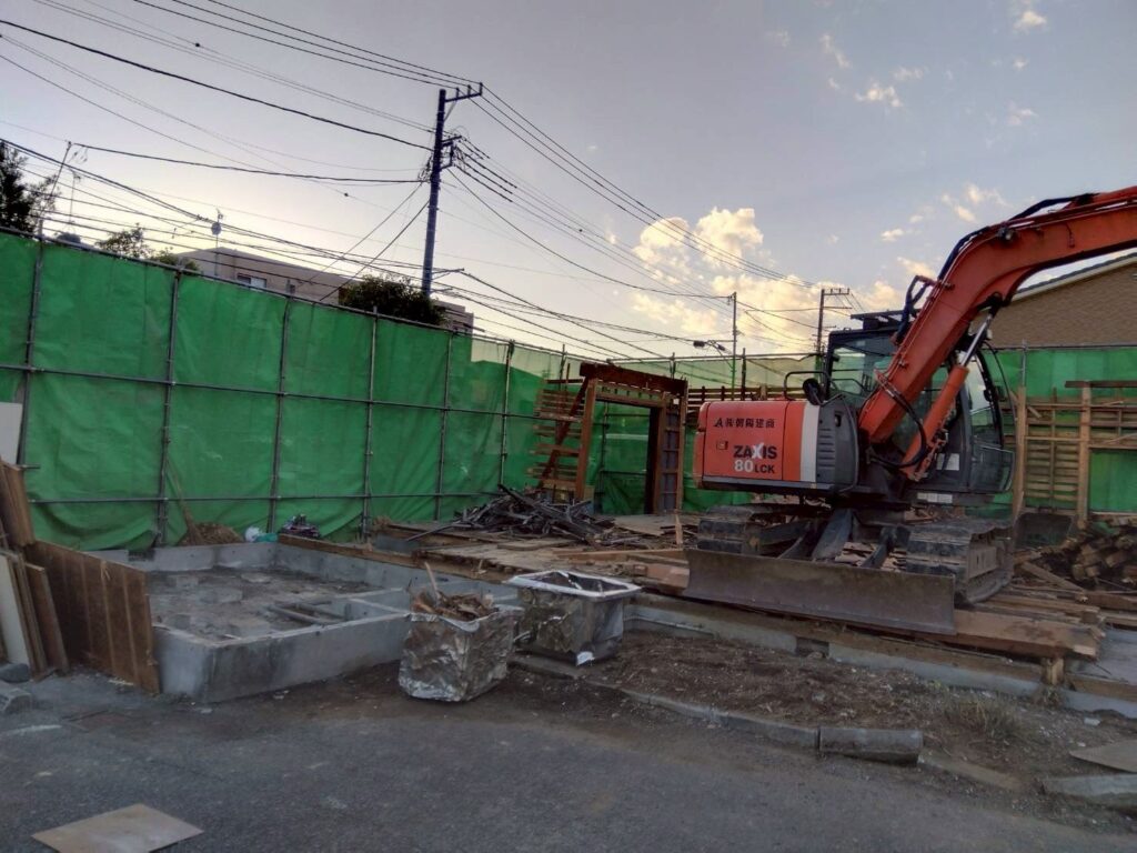 解体工事現場で、重機を使用して建物を解体している様子