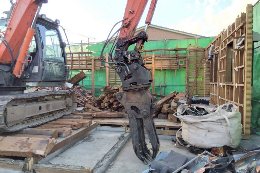 重機を使用して木造住宅を解体する様子